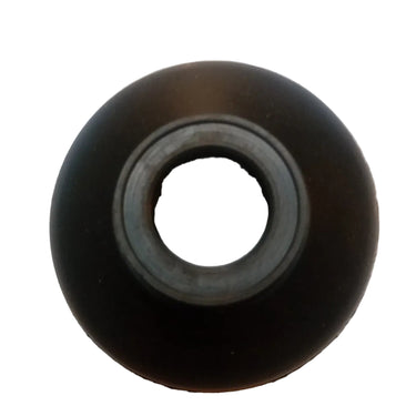 A single black circular rubber or plastic component with a hollow center, photographed on a plain white surface with a bright overhead light reflection above it.